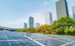 Facility management, cleaning, energy management, an image of solar panels surrounded by trees in the front and office buildings in the back 